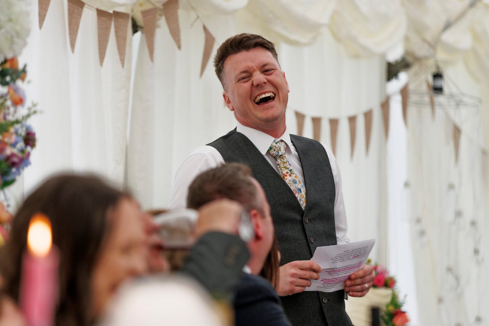 Best man laughing during a lively wedding speech