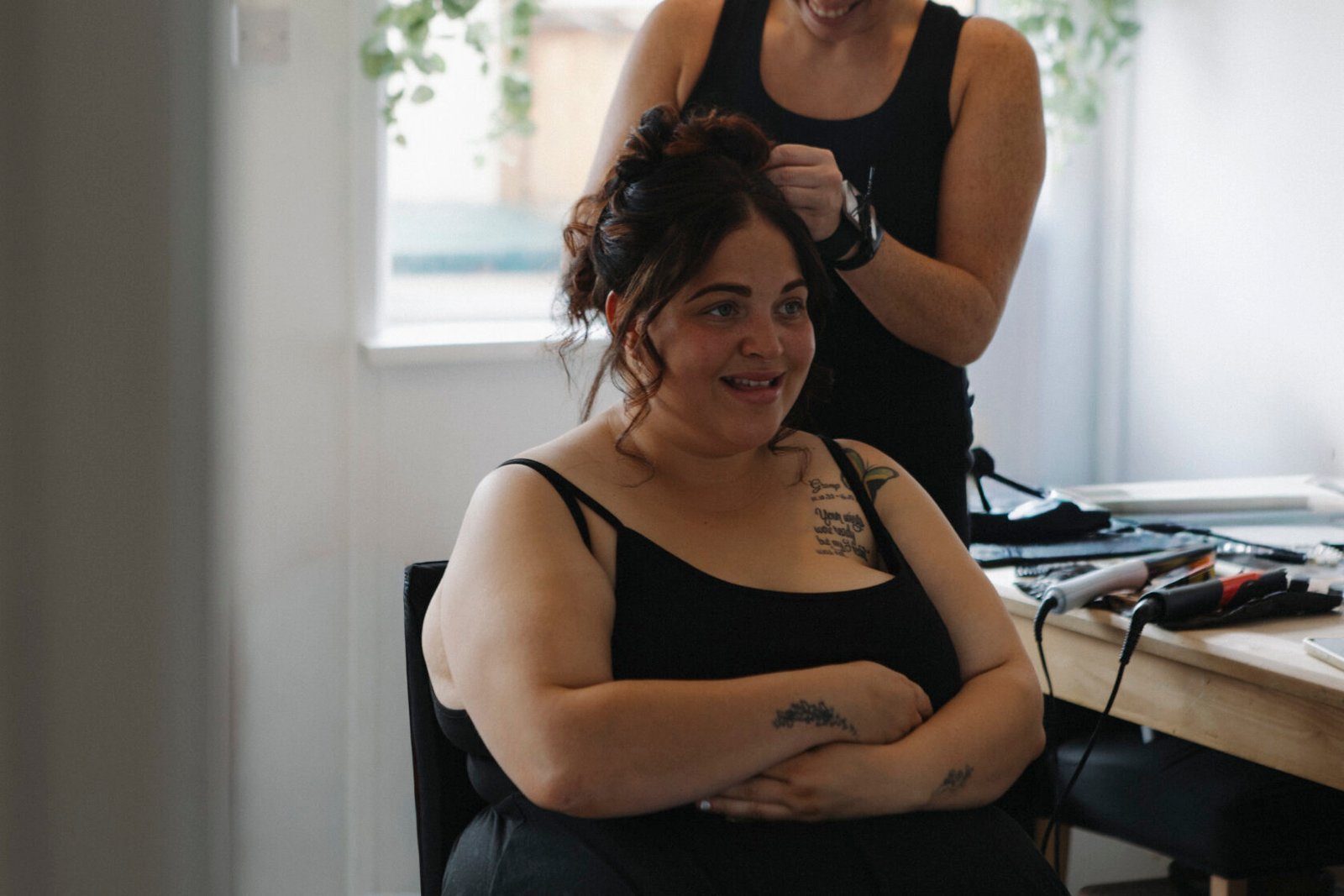 Bride smiling while her hair is styled on the wedding morning