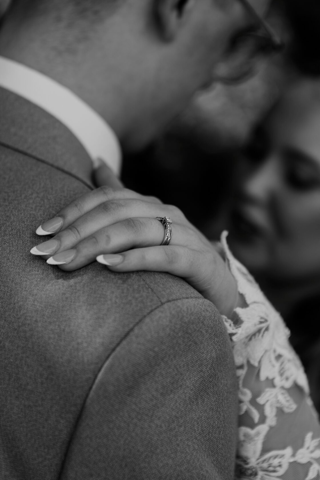Bride embracing the groom with her wedding ring in focus