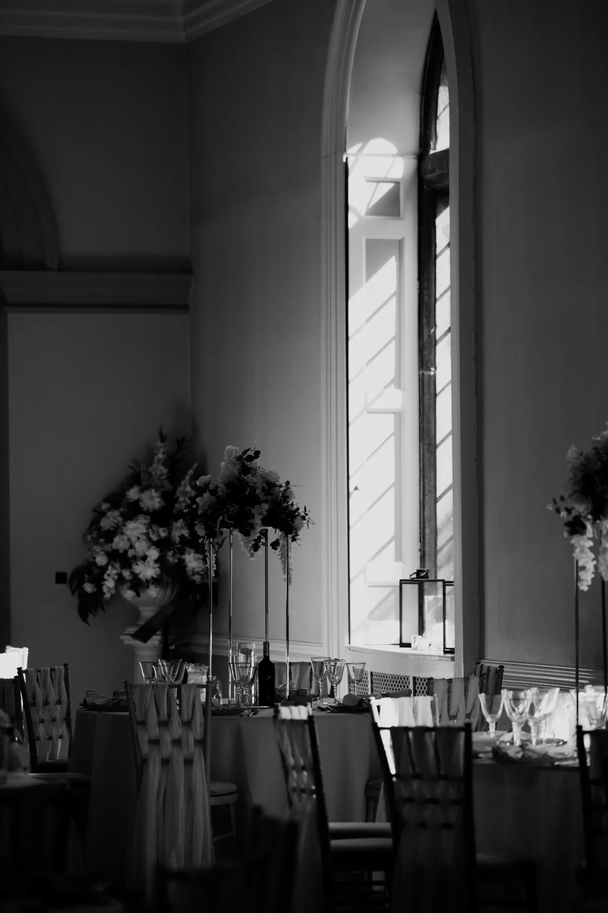 Black and white photograph of window light and flowers in the Clearwell Castle Ballroom