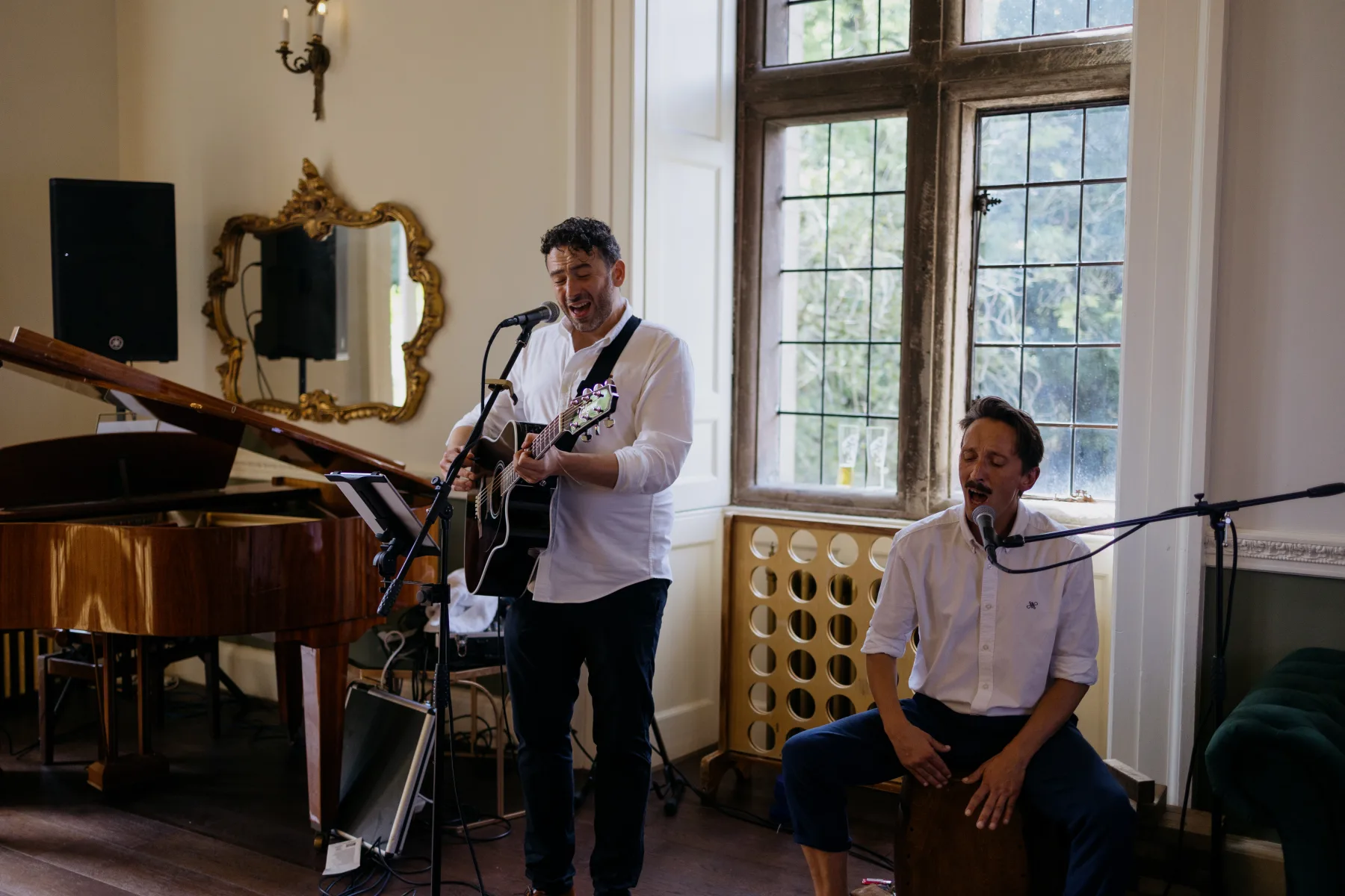 Two musicians performing beside the grand piano at a Clearwell Castle wedding