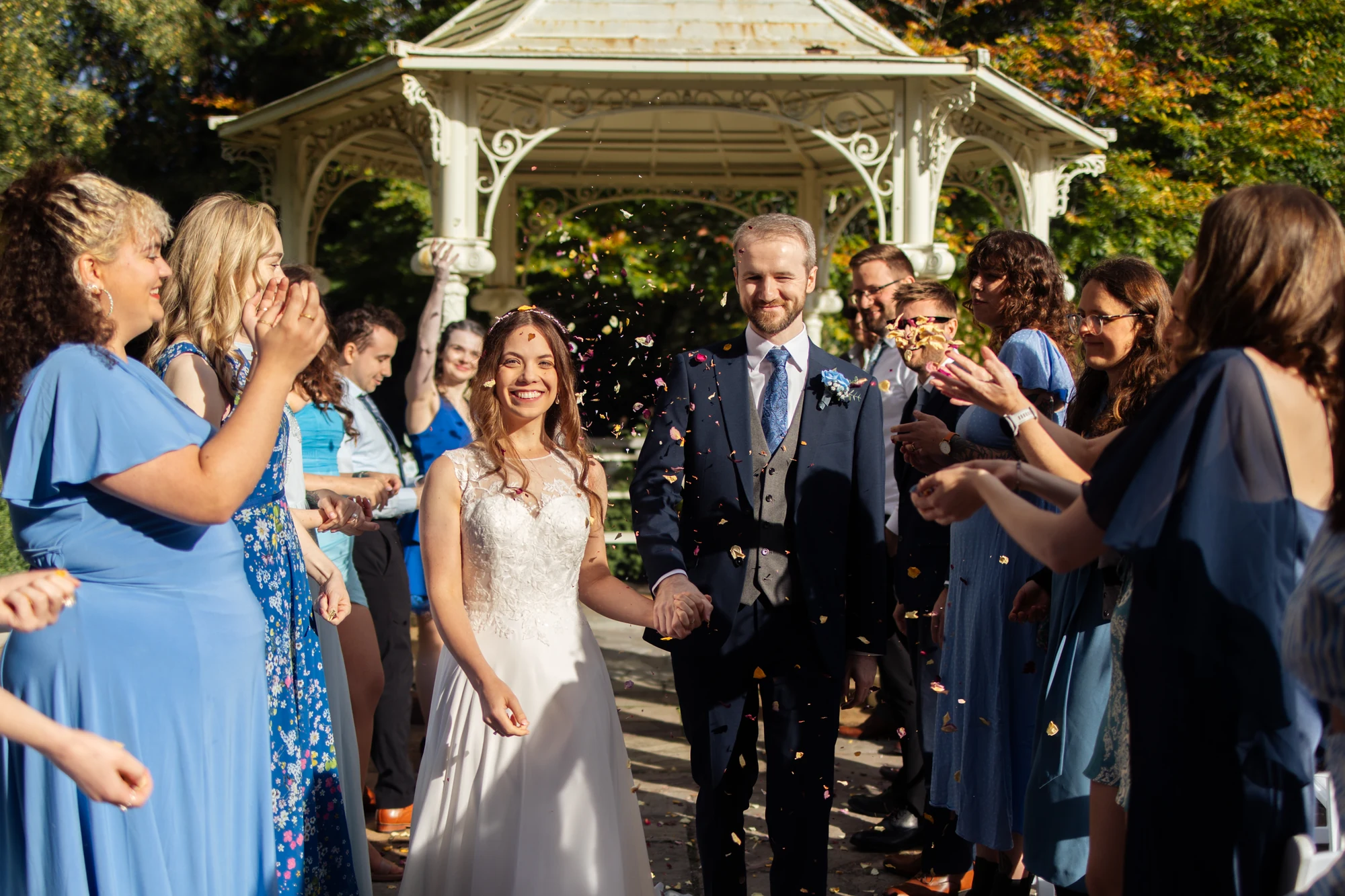 Amy and James walking through confetti with friends beside the rotunda