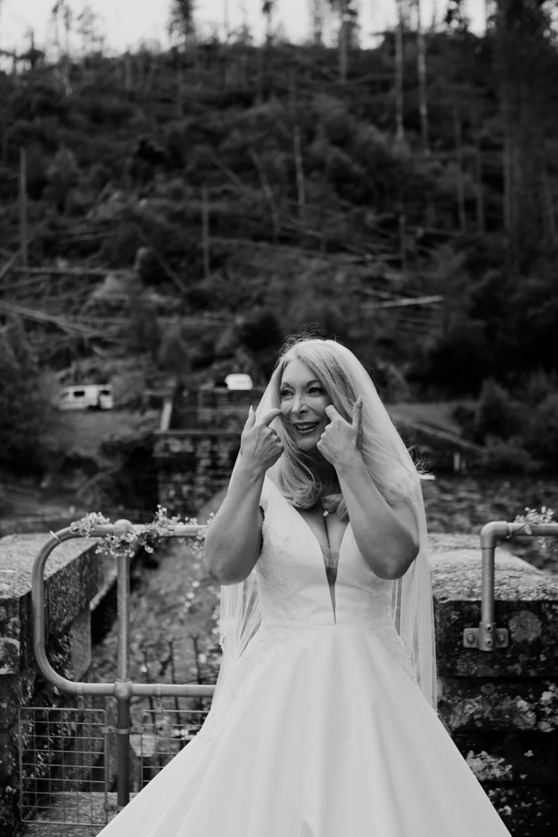 Bride smiling and playfully covering her face in a black-and-white portrait