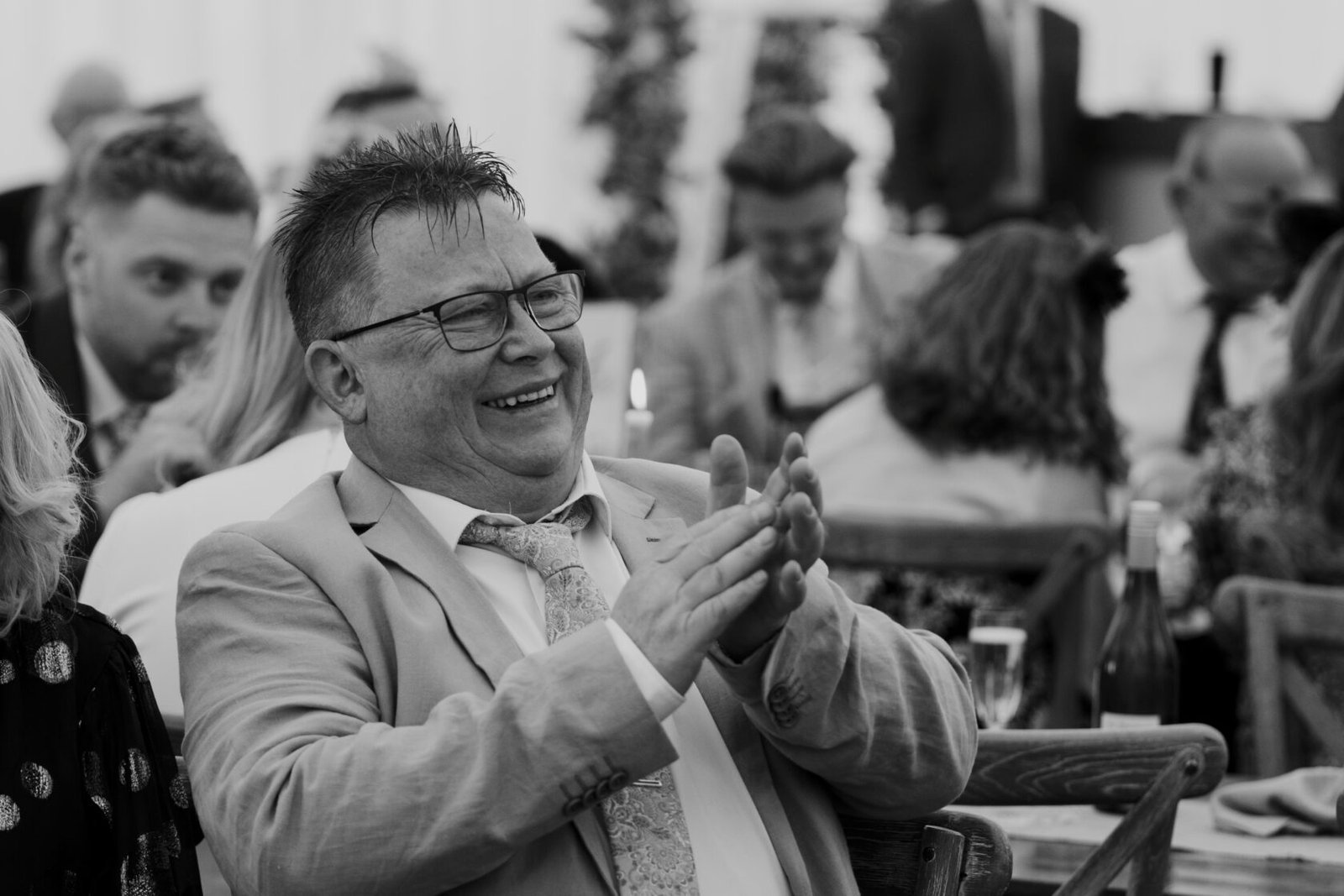 Wedding guest laughing and applauding at the reception