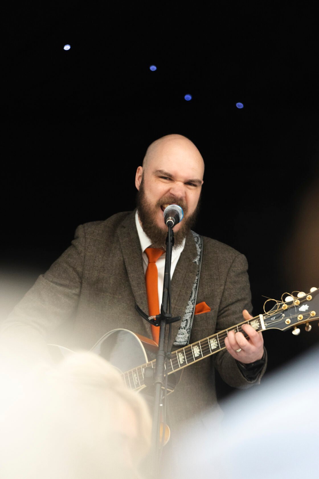 Live singer performing with a guitar during the wedding reception
