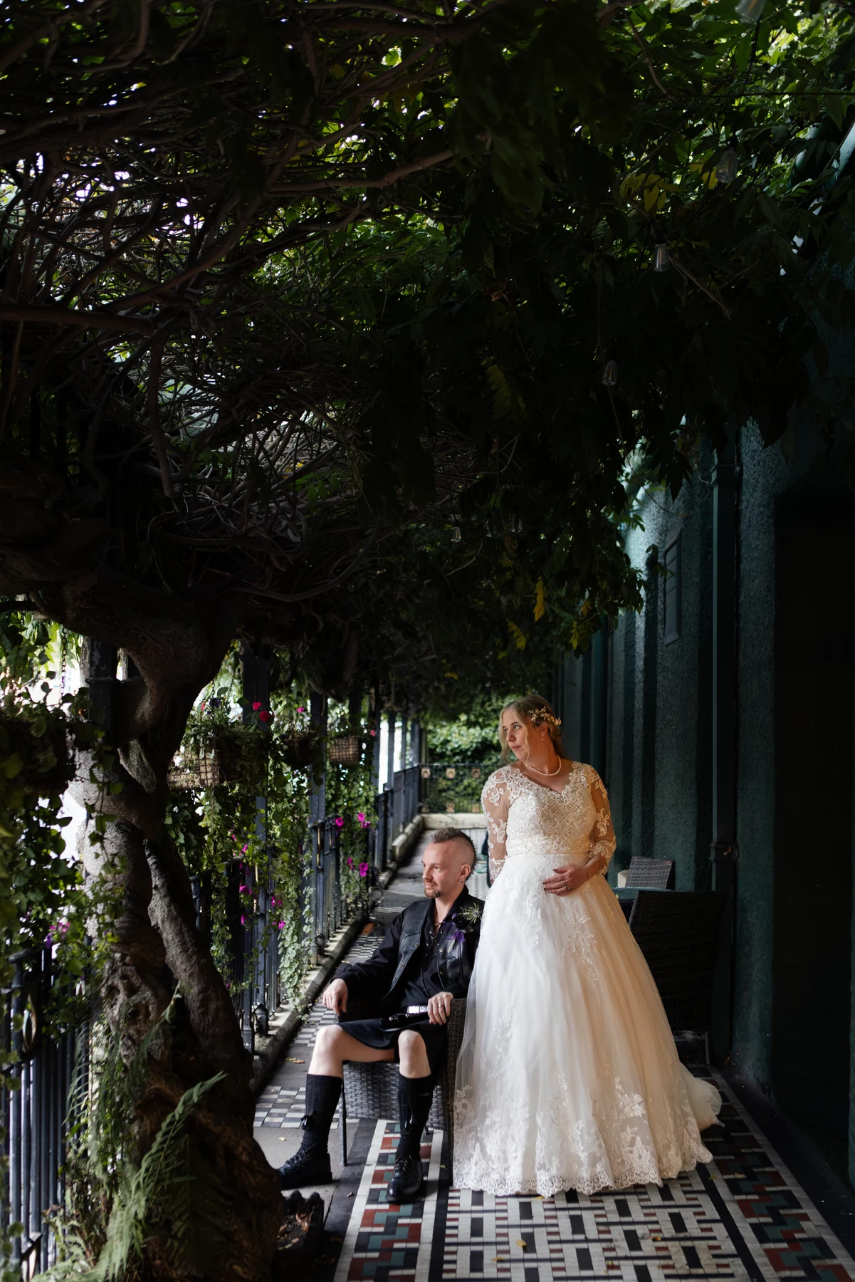 Ruth and David beneath leafy branches on the tiled terrace at the Metropole