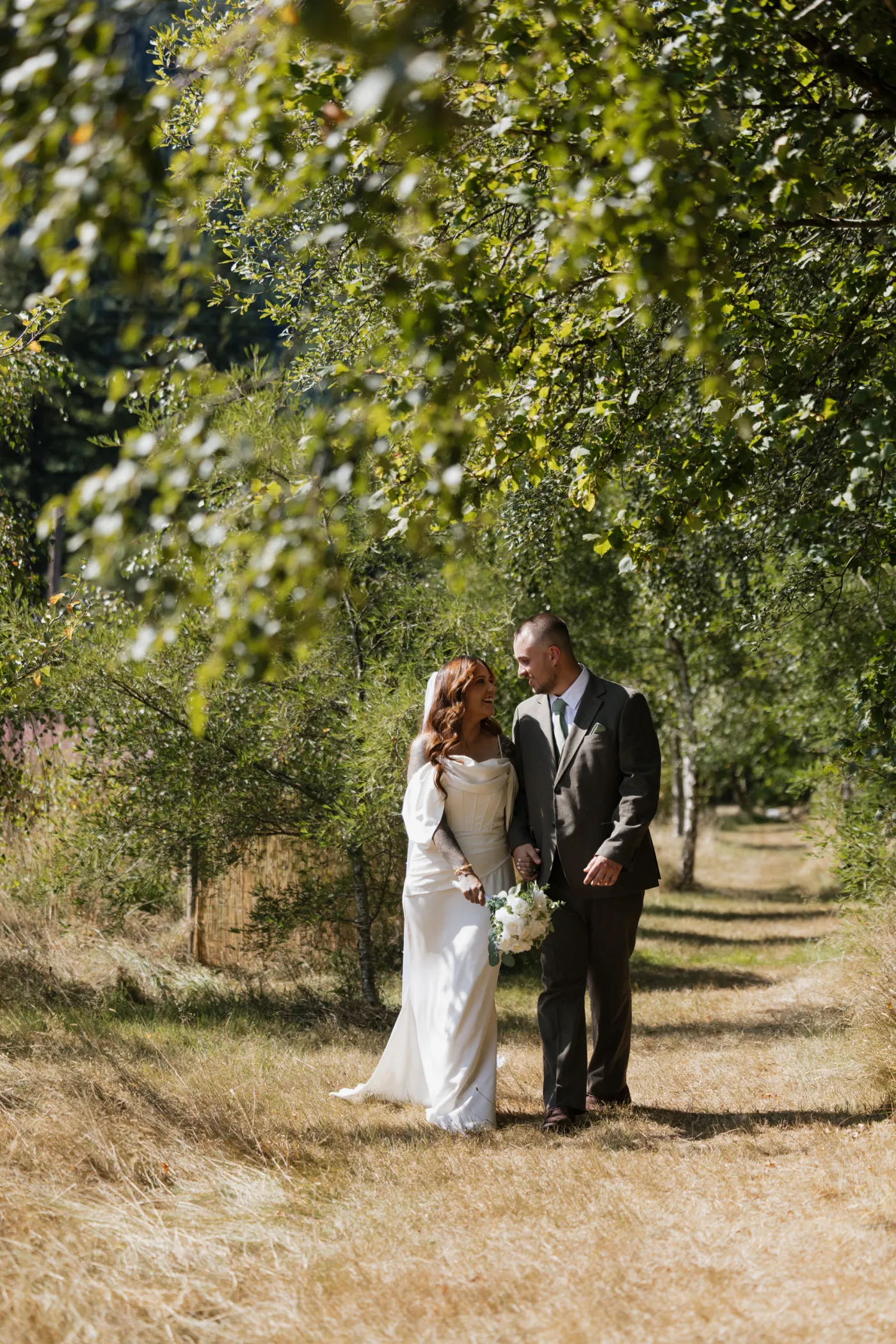 Autumn and Sebastian laughing during relaxed woodland wedding portraits
