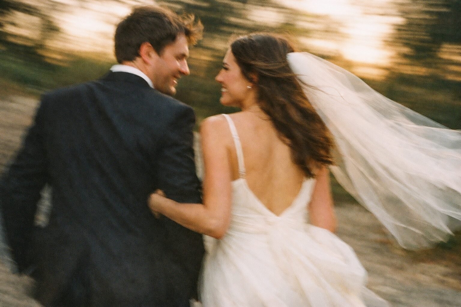 Newlyweds laughing together in warm golden-hour light