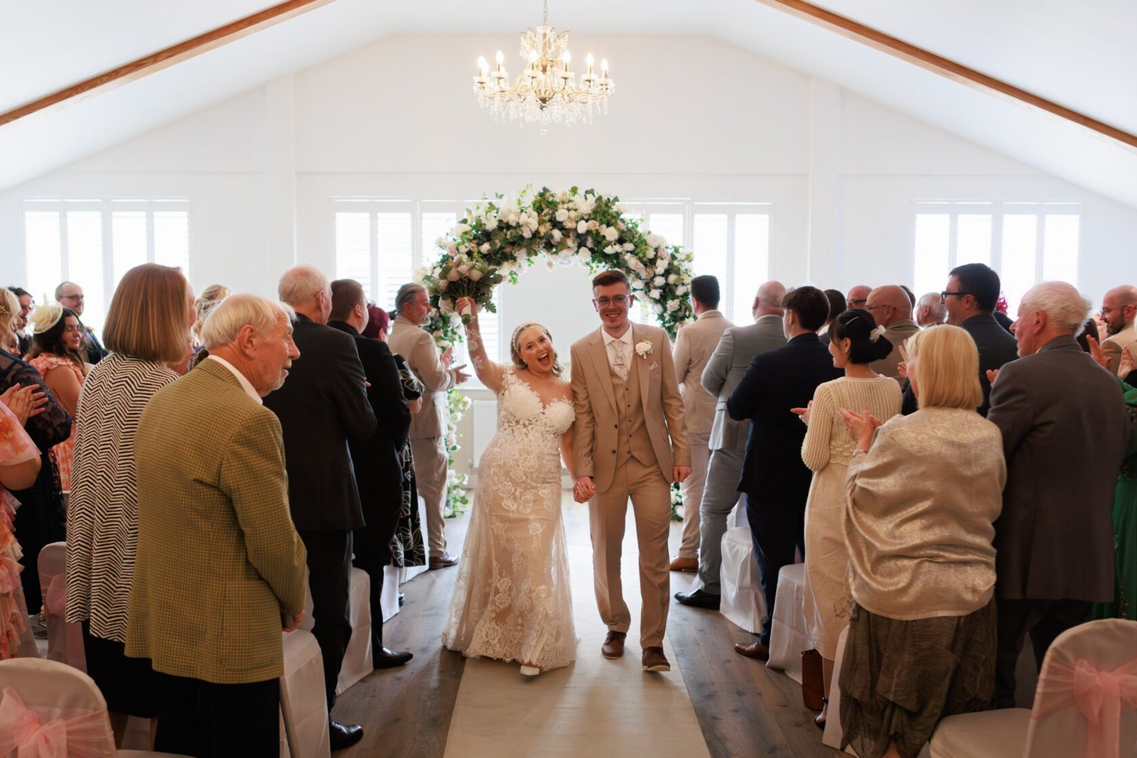 Newlyweds walking back down the aisle as guests celebrate