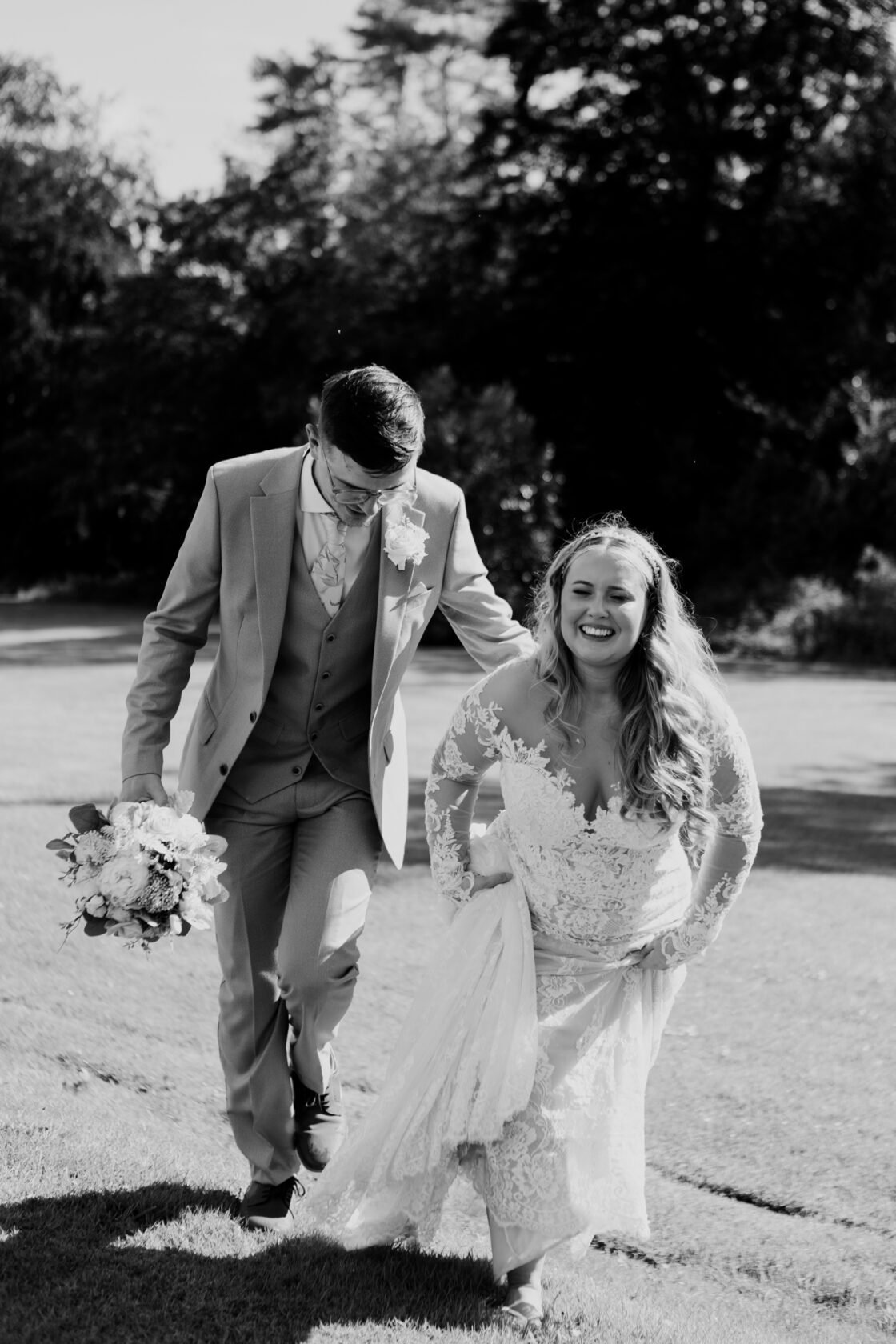 Newlyweds walking together from their reception in black and white