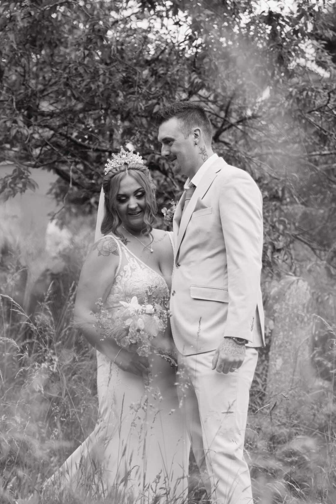 Newlyweds standing together in a quiet woodland portrait