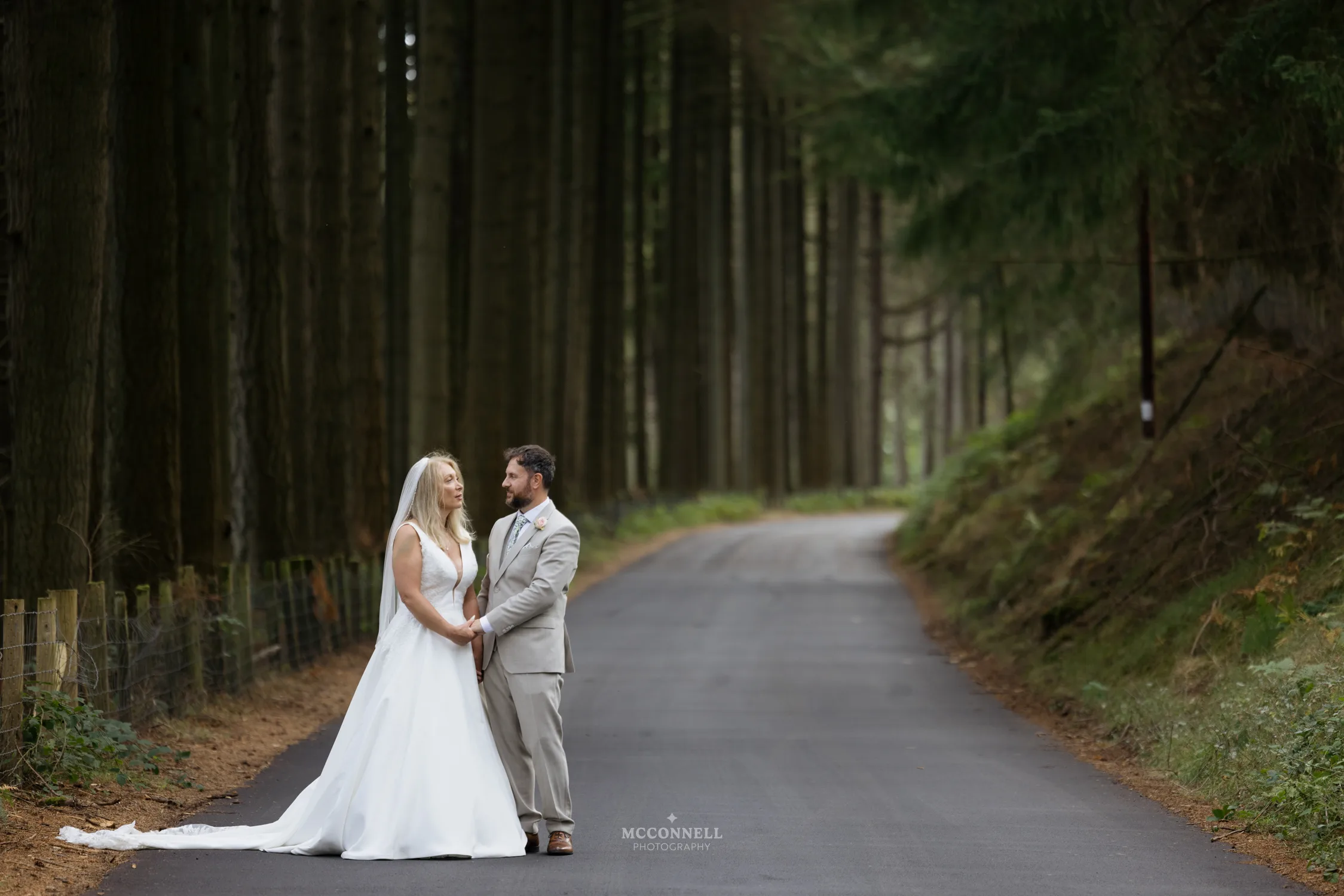Debi and Ryan holding hands on a quiet woodland road in the Elan Valley
