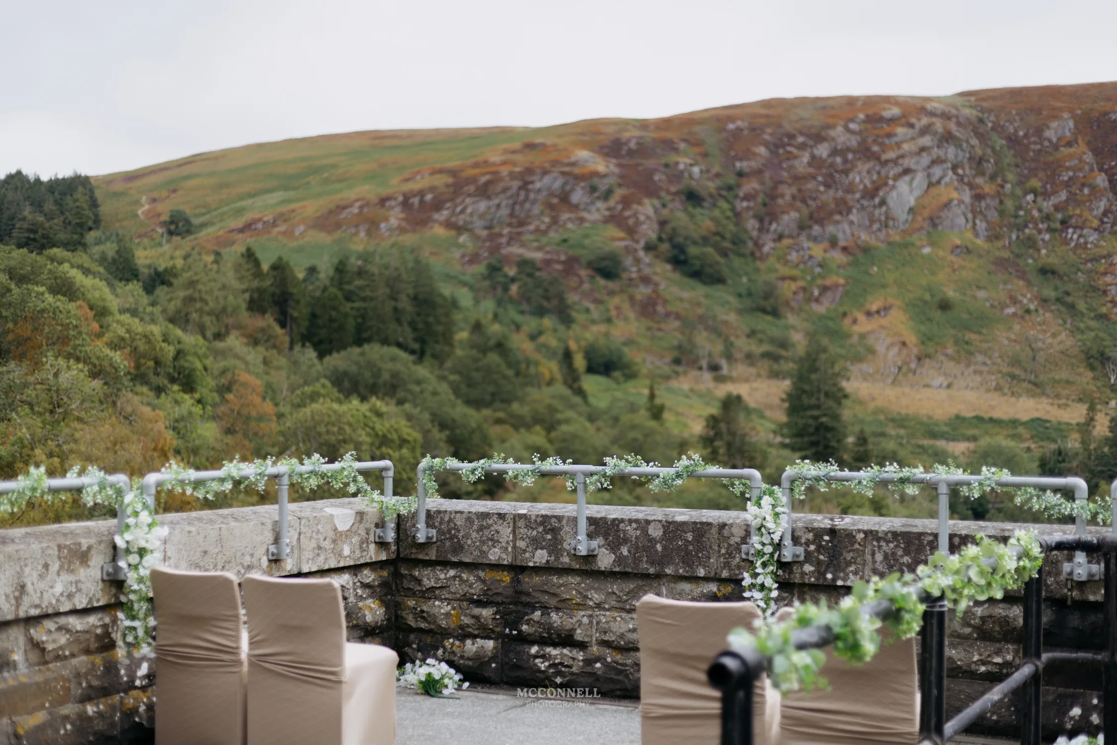 Wedding ceremony chairs and floral decorations on Pen y Garreg Dam overlooking the Elan Valley hills