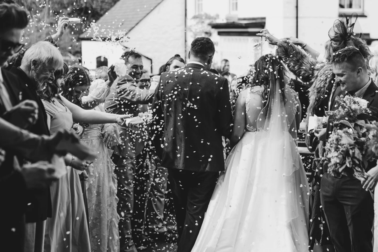 Newlyweds celebrating as guests throw confetti